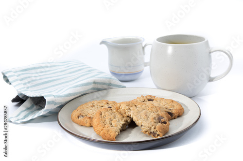 oatmeal raisin cookies  one broken in half  on a plate with a cup of coffee