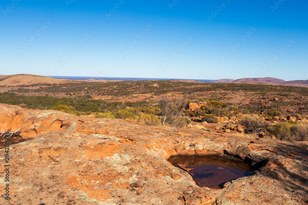 Pool of water in granite rocks under a blue sky in the Australian outback