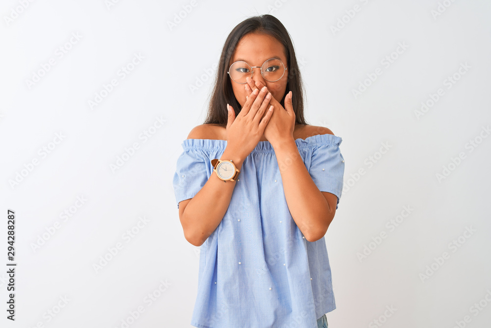 Young chinese woman wearing blue t-shirt and glasses over isolated white background shocked covering mouth with hands for mistake. Secret concept. Young chinese woman wearing blue t-shirt and glasses over isolated white background shocked covering mouth with hands for mistake. Secret concept.