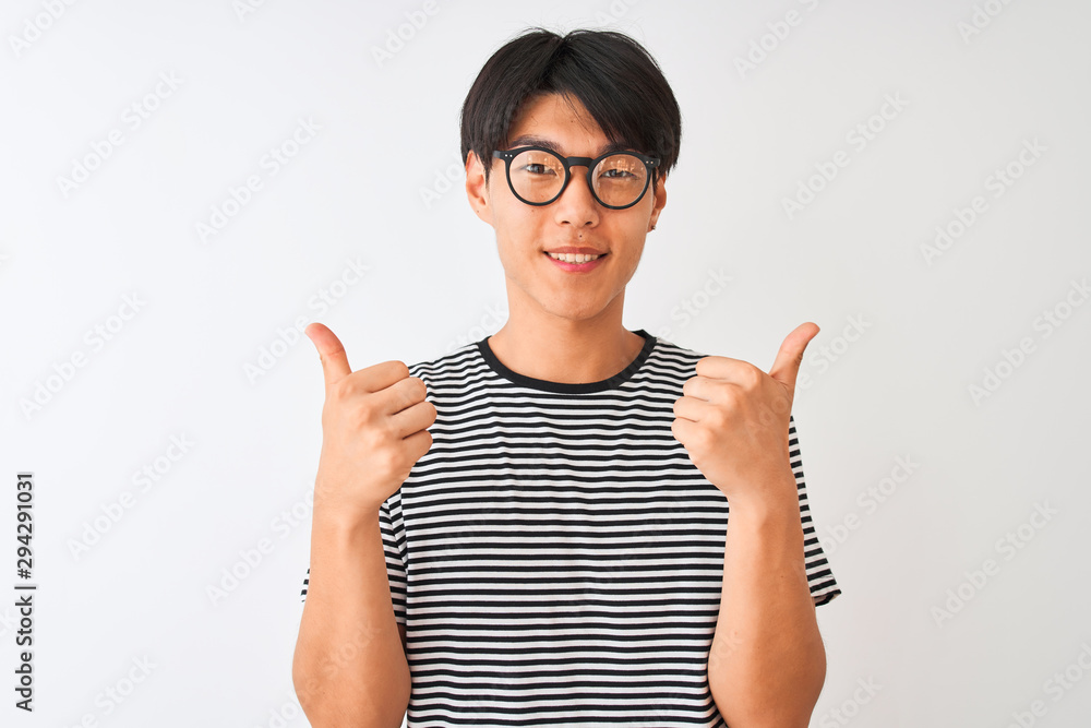 Chinese man wearing glasses and navy striped t-shirt standing over isolated white background success sign doing positive gesture with hand, thumbs up smiling and happy. Cheerful expression Chinese man wearing glasses and navy striped t-shirt standing over isolated white background success sign doing positive gesture with hand, thumbs up smiling and happy. Cheerful expression