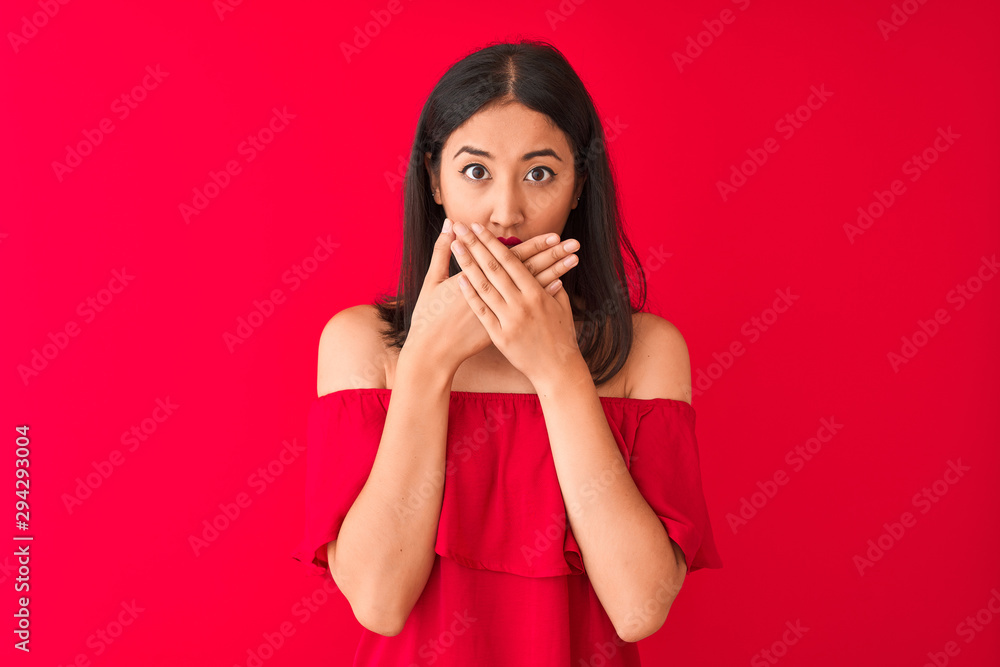 Young beautiful chinese woman wearing casual t-shirt standing over isolated red background shocked covering mouth with hands for mistake. Secret concept. Young beautiful chinese woman wearing casual t-shirt standing over isolated red background shocked covering mouth with hands for mistake. Secret concept.
