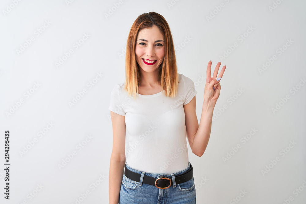 Beautiful redhead woman wearing casual t-shirt standing over isolated white background showing and pointing up with fingers number three while smiling confident and happy. Beautiful redhead woman wearing casual t-shirt standing over isolated white background showing and pointing up with fingers number three while smiling confident and happy.