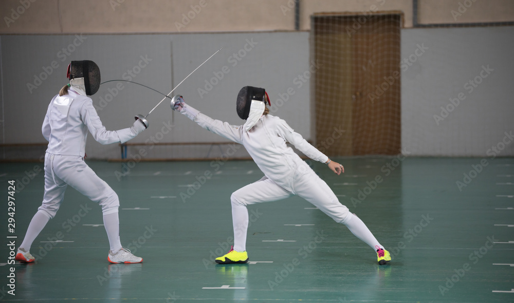 Two young women having a fencing training Two young women having a fencing training