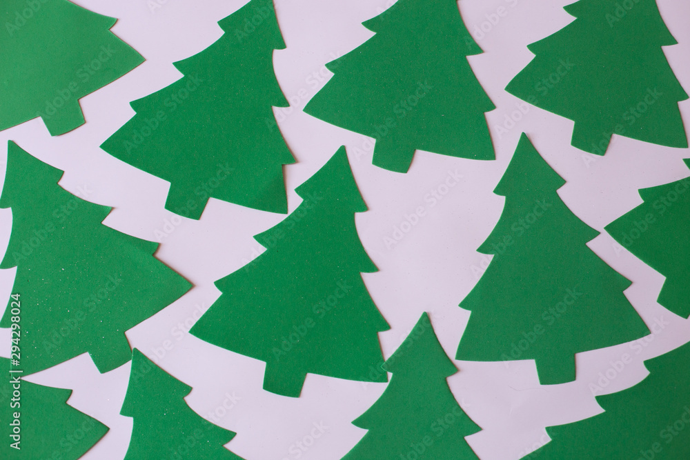 Fototapeta premium Christmas mood flat lay. Happy New Year flat lay on the paper. Green Christmas trees pattern on white paper