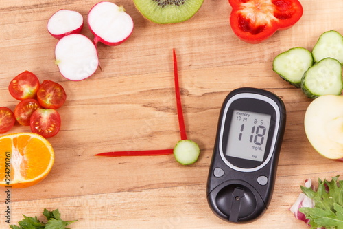 Glucometer with sugar level and fruits with vegetables in shape of clock, healthy breakfast for diabetics concept