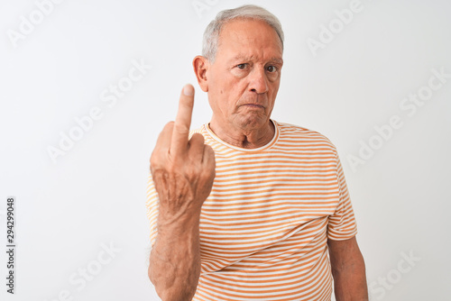Senior grey-haired man wearing striped t-shirt standing over isolated white background Showing middle finger, impolite and rude fuck off expression
