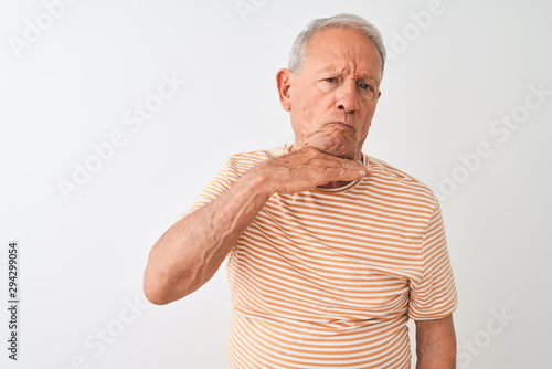 Senior grey-haired man wearing striped t-shirt standing over isolated white background cutting throat with hand as knife, threaten aggression with furious violence