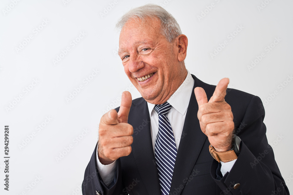 Senior grey-haired businessman wearing suit standing over isolated white background pointing fingers to camera with happy and funny face. Good energy and vibes. Senior grey-haired businessman wearing suit standing over isolated white background pointing fingers to camera with happy and funny face. Good energy and vibes.