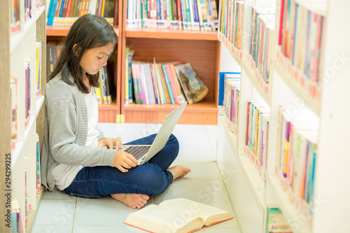 Young student girl sitting  in a library