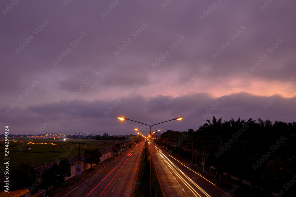sunset behind the cloud in the city on the overpass street lamp