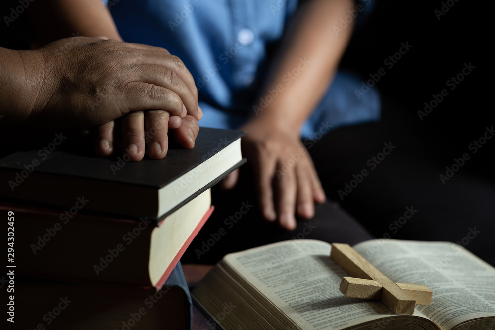 Family group are praying together on wooden table Family group are praying together on wooden table