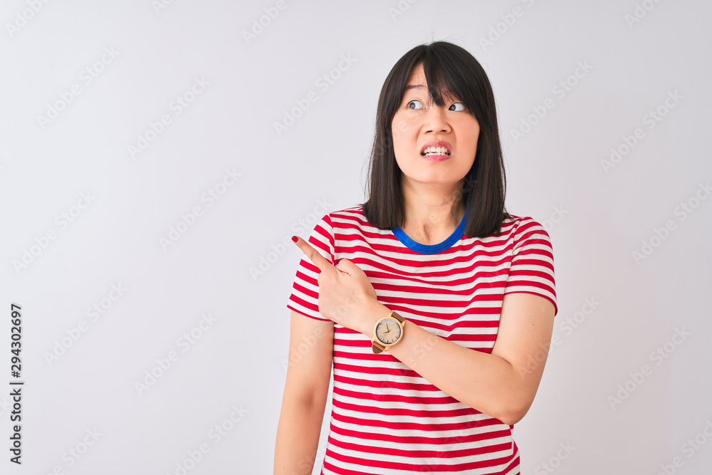 Young beautiful chinese woman wearing red striped t-shirt over isolated white background Pointing aside worried and nervous with forefinger, concerned and surprised expression Young beautiful chinese woman wearing red striped t-shirt over isolated white background Pointing aside worried and nervous with forefinger, concerned and surprised expression