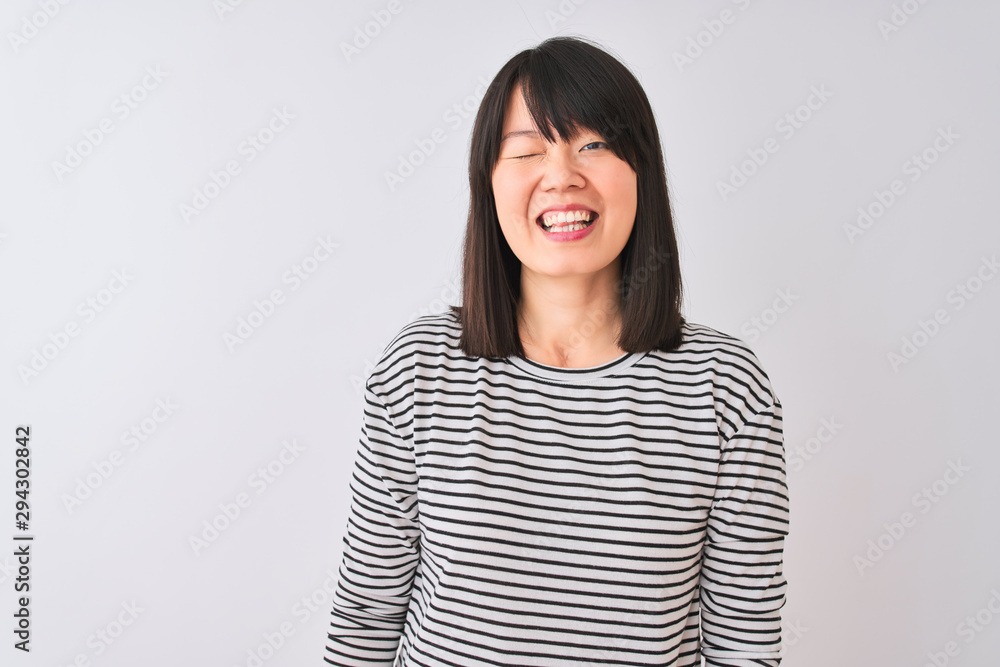 Young beautiful chinese woman wearing black striped t-shirt over isolated white background winking looking at the camera with sexy expression, cheerful and happy face. Young beautiful chinese woman wearing black striped t-shirt over isolated white background winking looking at the camera with sexy expression, cheerful and happy face.