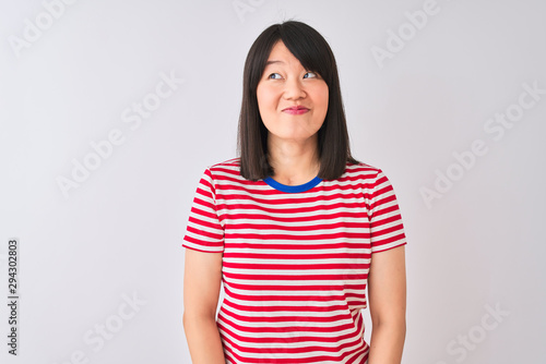 Young beautiful chinese woman wearing red striped t-shirt over isolated white background smiling looking to the side and staring away thinking. © Krakenimages.com