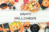 Table top view aerial image of decorations Happy Halloween day background holiday concept.Flat lay objects to party pumpkins and spider with candy sweet on white wooden wallpaper.text design season.
