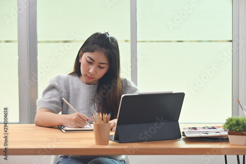 Young creative woman working with tablet.