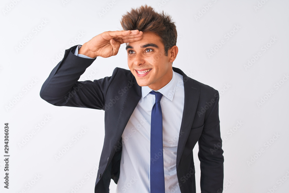 Young handsome businessman wearing suit standing over isolated white background very happy and smiling looking far away with hand over head. Searching concept. Young handsome businessman wearing suit standing over isolated white background very happy and smiling looking far away with hand over head. Searching concept.