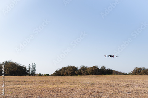 a drone flying over green field on the open field park area in the morning 