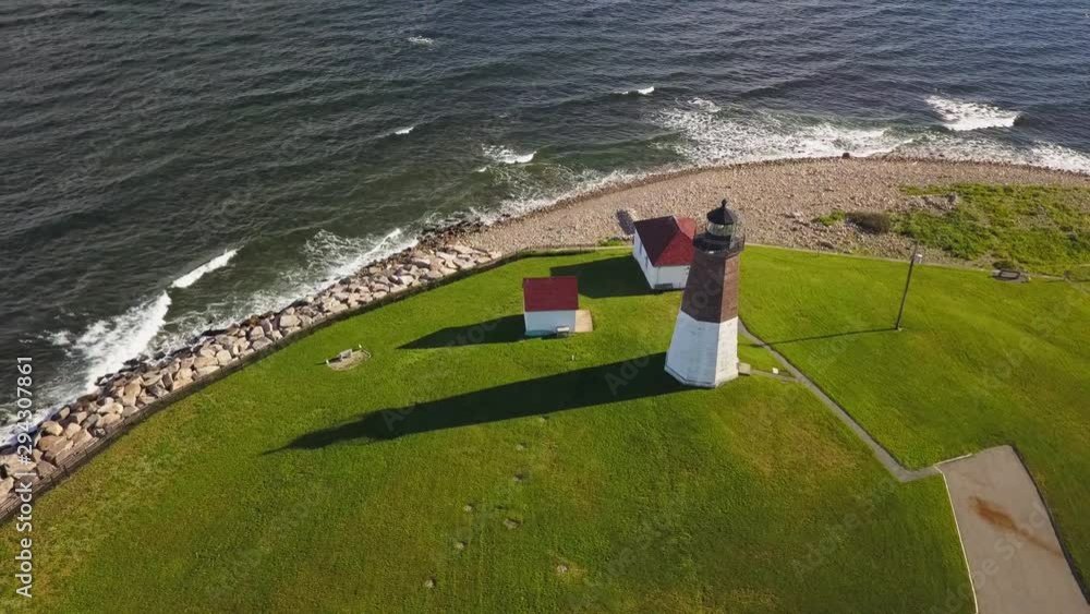 Lighthouse beacon across ocean aerial view tilt up to reveal horizon Lighthouse beacon across ocean aerial view tilt up to reveal horizon