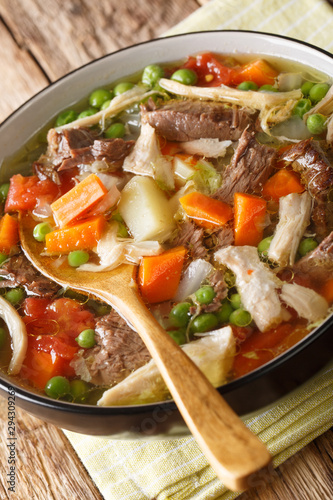 Slow Cooker Belgian Booyah soup with vegetables and meat close-up in a bowl. vertical photo