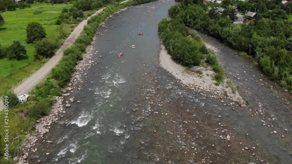 Aerial shot of people white water rafting on beautiful mountain river. Group of people enjoying adrenaline rafting sport Aerial shot of people white water rafting on beautiful mountain river. Group of people enjoying adrenaline rafting sport
