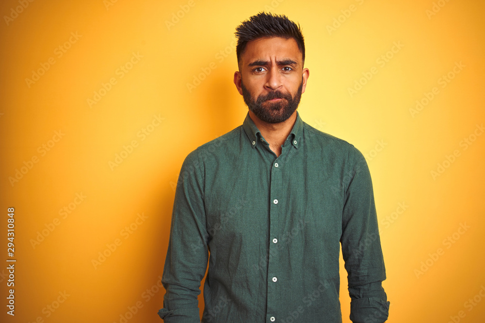 Obraz premium Young indian businessman wearing elegant shirt standing over isolated white background depressed and worry for distress, crying angry and afraid. Sad expression.