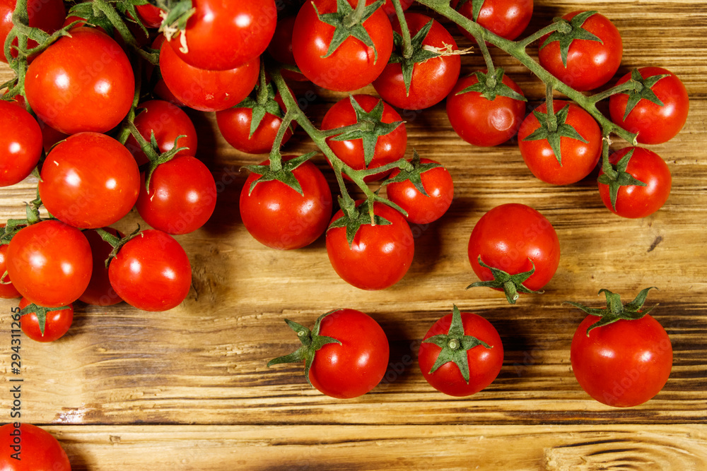 Fresh cherry tomatoes on a wooden table. Top view Fresh cherry tomatoes on a wooden table. Top view