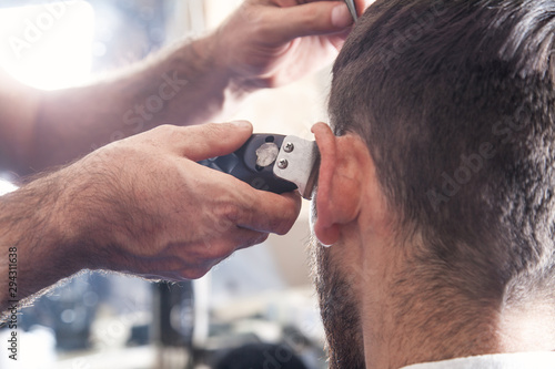 Professional hairdresser using hair cutting machine.