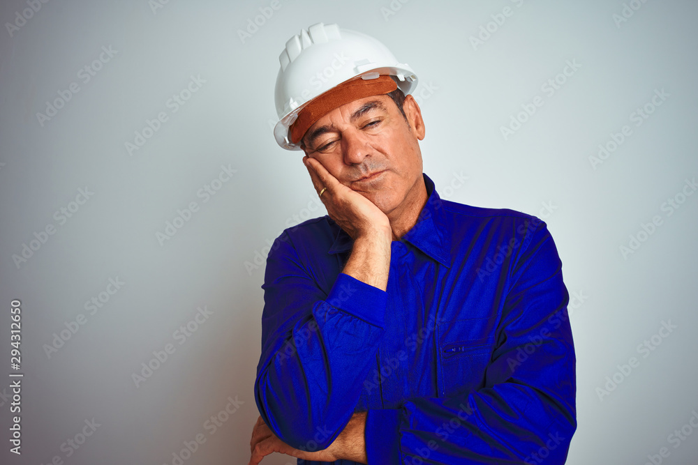 Handsome middle age worker man wearing uniform and helmet over isolated white background thinking looking tired and bored with depression problems with crossed arms. Handsome middle age worker man wearing uniform and helmet over isolated white background thinking looking tired and bored with depression problems with crossed arms.
