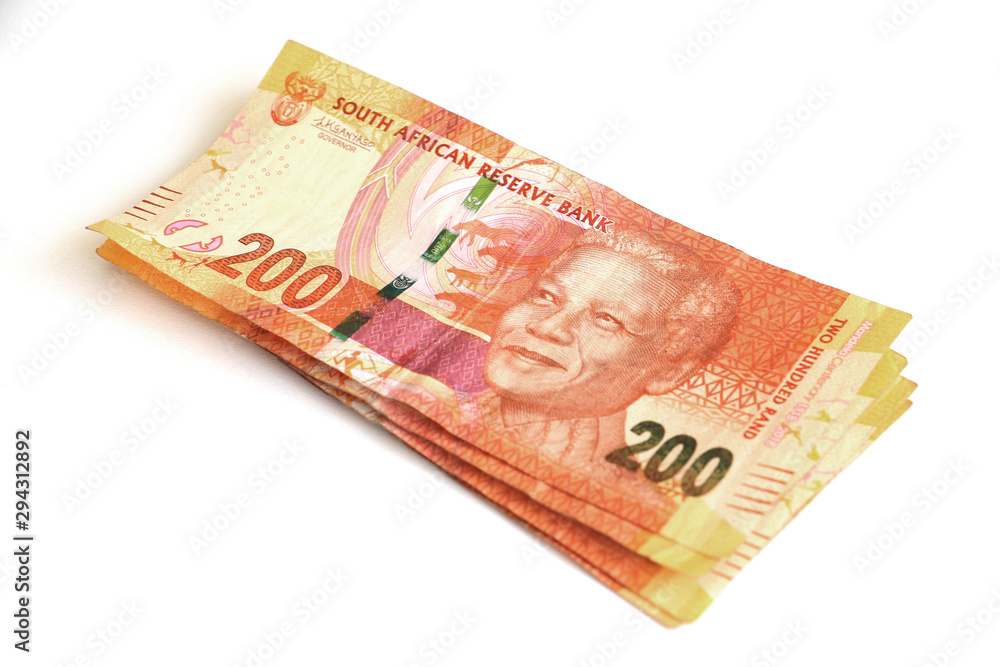 South African money, currency, orange two hundred rand notes stacked and isolated on a white background featuring Nelson Mandela South African money, currency, orange two hundred rand notes stacked and isolated on a white background featuring Nelson Mandela