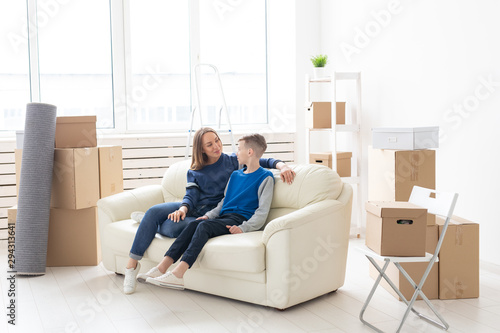 Cute single mom and little boy son relaxing after the move. The concept of housewarming mortgage and the joy of new housing. © satura_