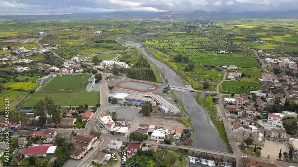 Panning drone shot over Peristerona. Aerial shot. River and town. Panning drone shot over Peristerona. Aerial shot. River and town.