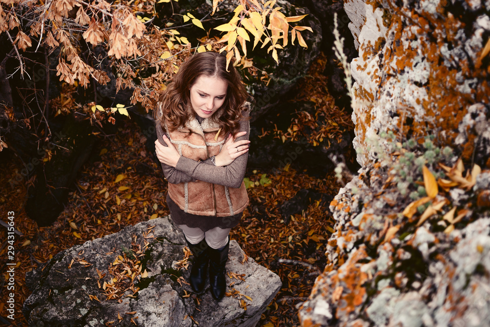a modest woman is standing with downcast eyes and folded hands on his chest in the fall a modest woman is standing with downcast eyes and folded hands on his chest in the fall