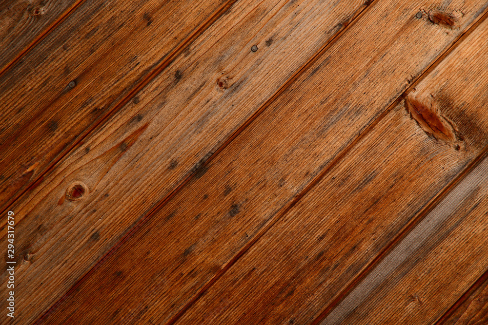 Obraz premium Abstract natural background. Top view on the surface of diagonal brown wooden planks. Close-up, horizontal, cropped shot, free space. Construction and woodworking concept.