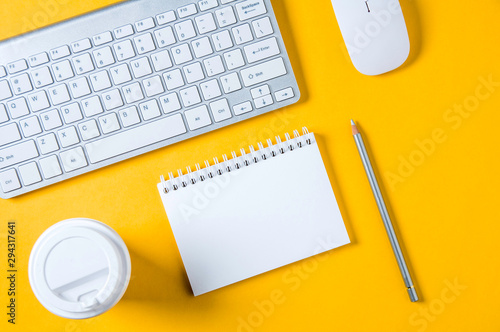 White keyboard, mouse and Notepad on yellow background. Flat lay and top view