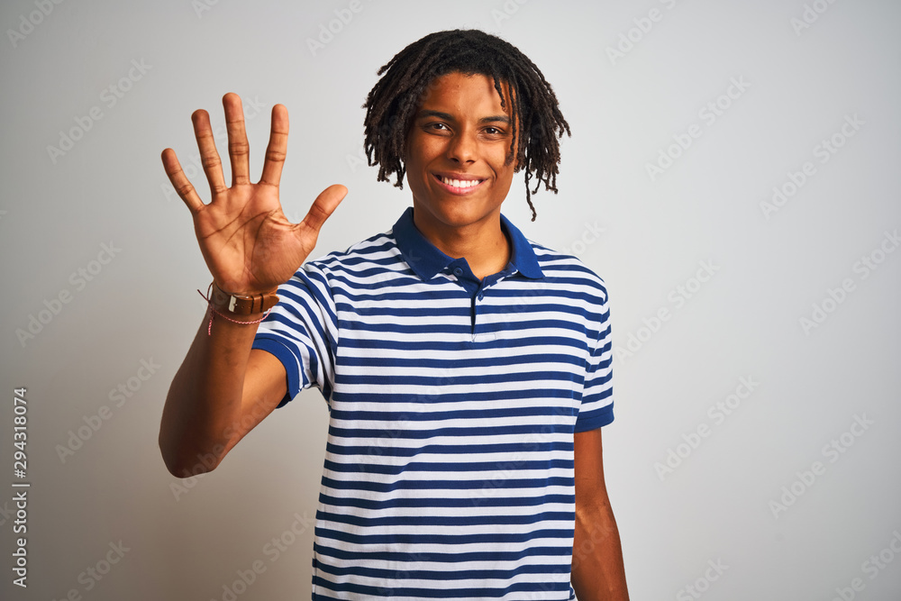 Afro man with dreadlocks wearing striped blue polo standing over isolated white background showing and pointing up with fingers number five while smiling confident and happy. Afro man with dreadlocks wearing striped blue polo standing over isolated white background showing and pointing up with fingers number five while smiling confident and happy.