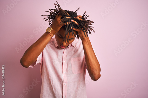 Canvas-taulu Afro american man with dreadlocks wearing elegant shirt standing over isolated pink background suffering from headache desperate and stressed because pain and migraine