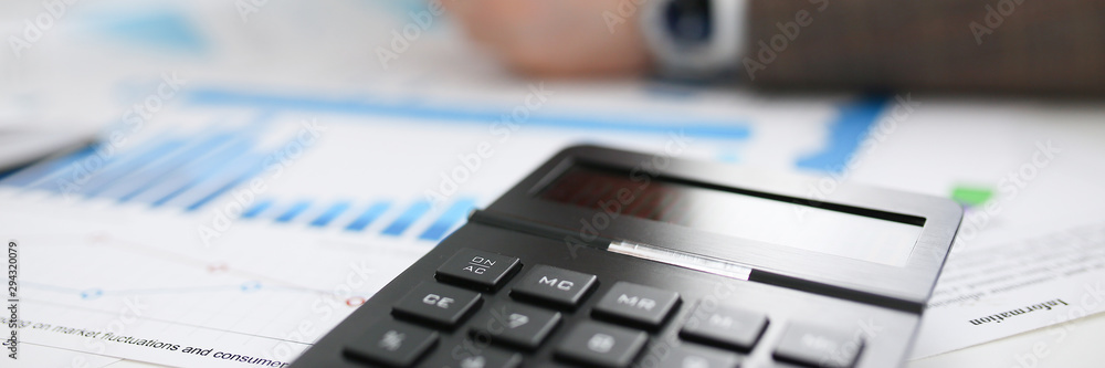 Black calculator and financial statistics on clipboard pad at office table closeup. Internal Revenue Service inspector sum check irs investigation earnings savings loan and credit concept Black calculator and financial statistics on clipboard pad at office table closeup. Internal Revenue Service inspector sum check irs investigation earnings savings loan and credit concept
