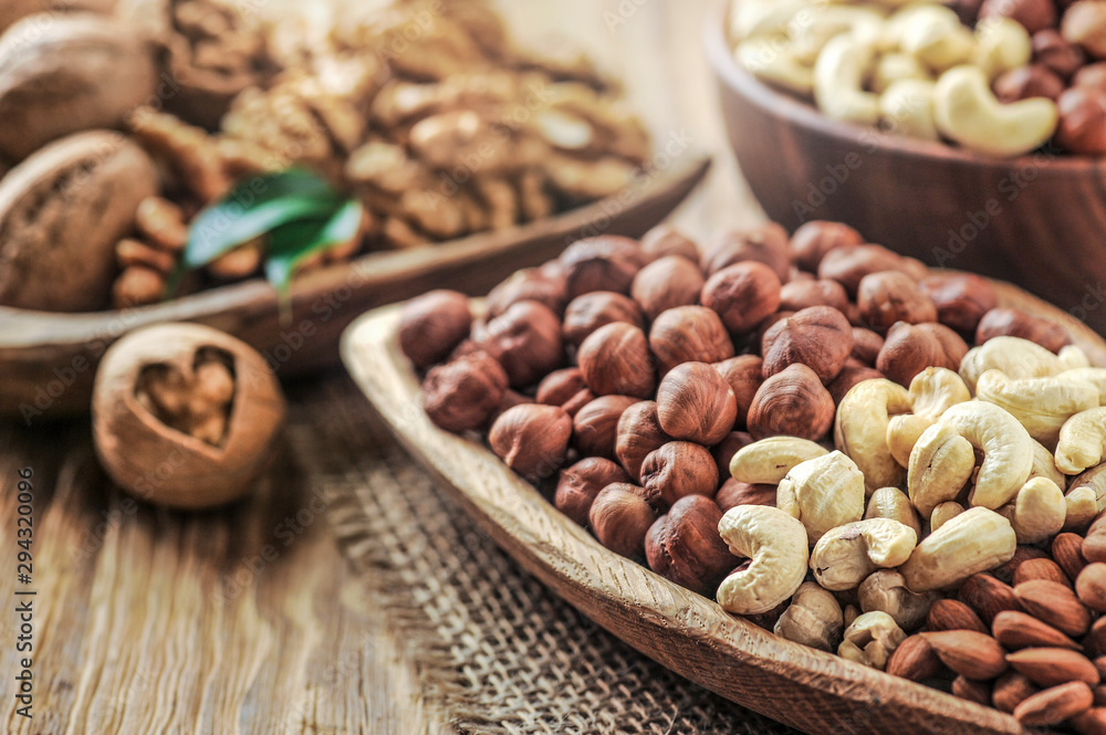 Mix nuts on wooden table. Nuts with walnut heart. Fresh raw nuts in bowls. Mix nuts on wooden table. Nuts with walnut heart. Fresh raw nuts in bowls.