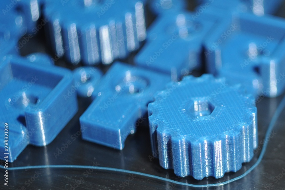 Details of blue plastic lying on the glass table of a 3D printer Details of blue plastic lying on the glass table of a 3D printer