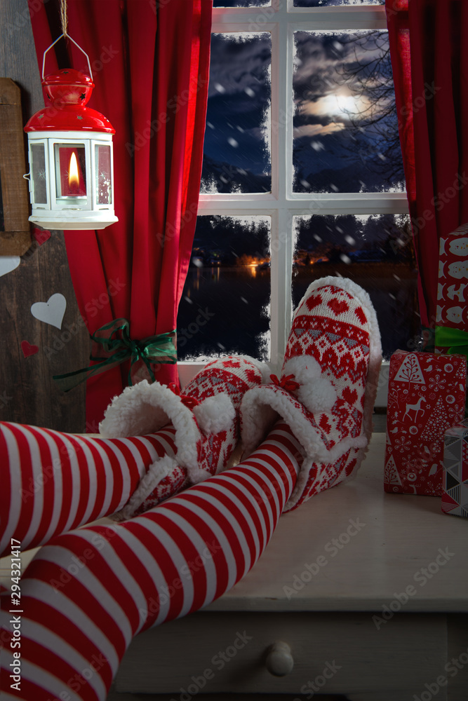 Woman legs with socks on table and  background of window, Christmas concept