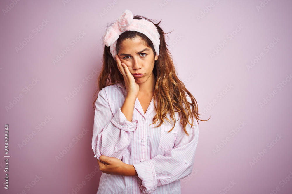 Young beautiful woman wearing pajama standing over pink isolated background thinking looking tired and bored with depression problems with crossed arms. Young beautiful woman wearing pajama standing over pink isolated background thinking looking tired and bored with depression problems with crossed arms.