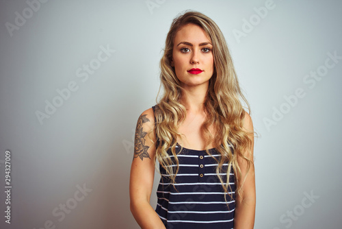 Young beautiful woman wearing stripes t-shirt standing over white isolated background looking sleepy and tired, exhausted for fatigue and hangover, lazy eyes in the morning.