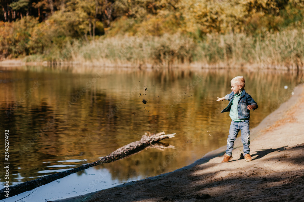 Portrait of cute smiling boy on a summer riverbank.