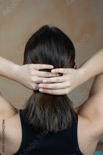 Rear view of a woman arranging her hair