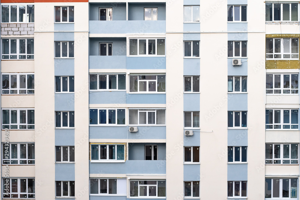 Facade of condominium. Multi-storey residential building. Abstract texture. Wall with windows and balconies of Russian and Ukrainian design, architecture background. Facade of condominium. Multi-storey residential building. Abstract texture. Wall with windows and balconies of Russian and Ukrainian design, architecture background.