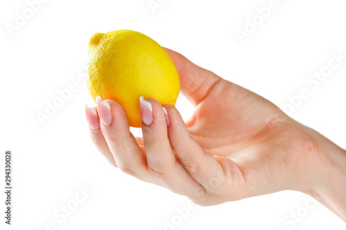 Lemon in woman hand isolated. Woman holding lemon in her fingers with beautiful nails on white background.