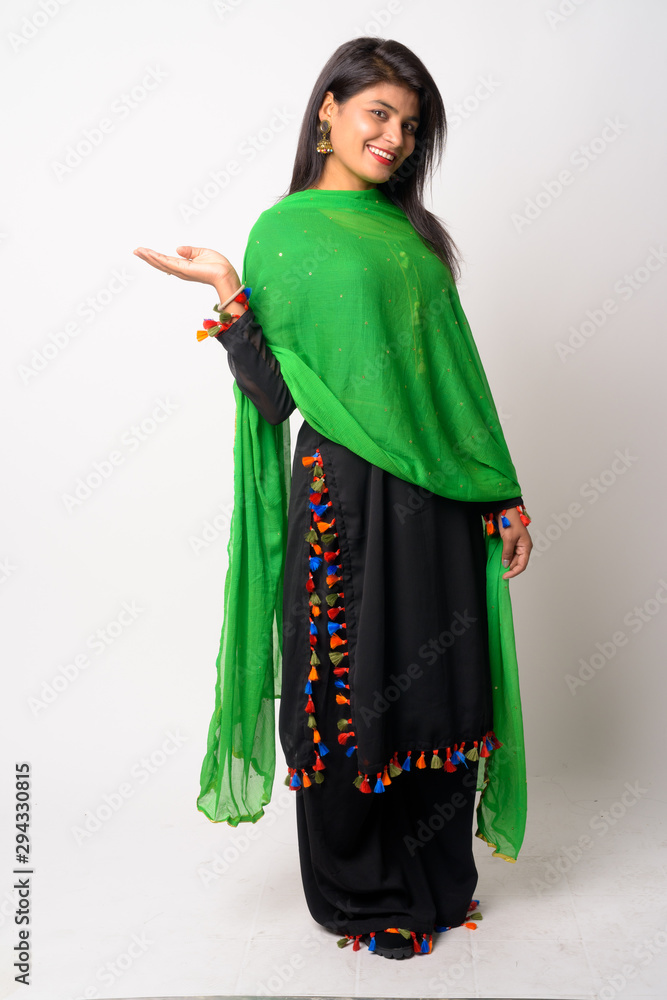 Full body shot of happy young Persian woman smiling in traditional clothing Full body shot of happy young Persian woman smiling in traditional clothing