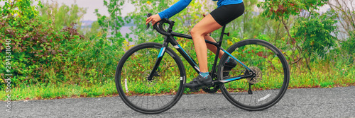 Road bike cyclist woman riding bicycle panoramic banner of legs and wheels. Sport active lifestyle panorama.