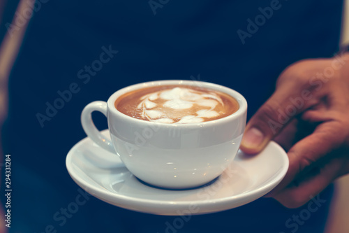 cup of coffee in a white cup on wooden background, coffee shop